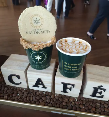 Copos com a identidade visual do evento Imersão Valor Med e café com latte art