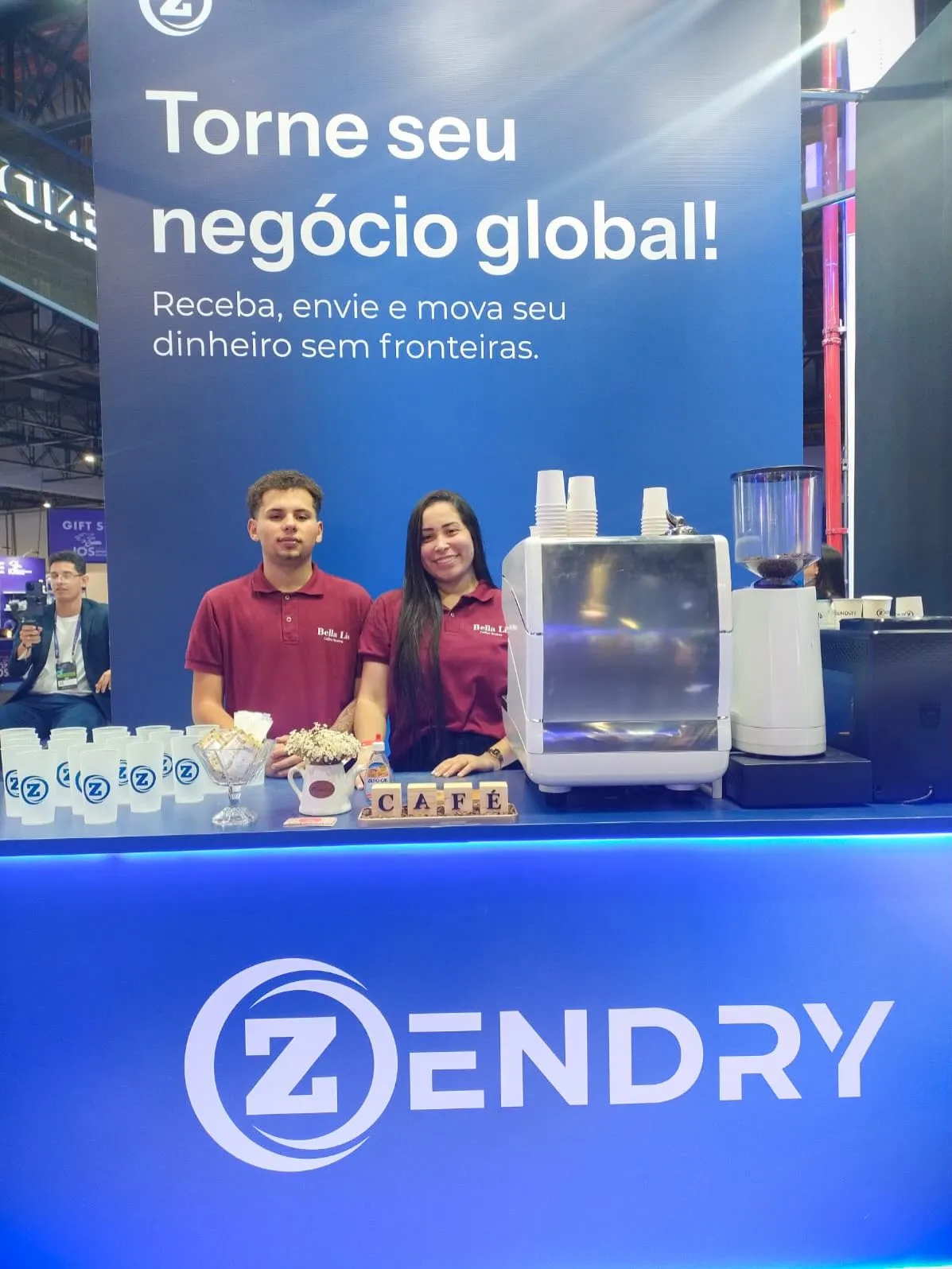 Baristas da Bella Lis uniformizados em estação de café personalizada com a marca Zendry em feira