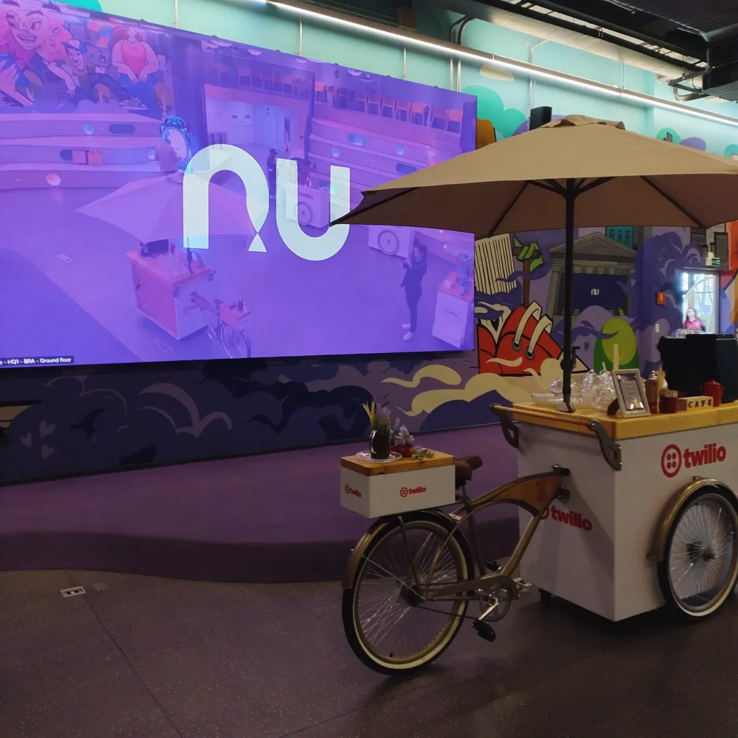 Carrinho de café personalizado Twilio com guarda-sol em evento na sede do Nubank