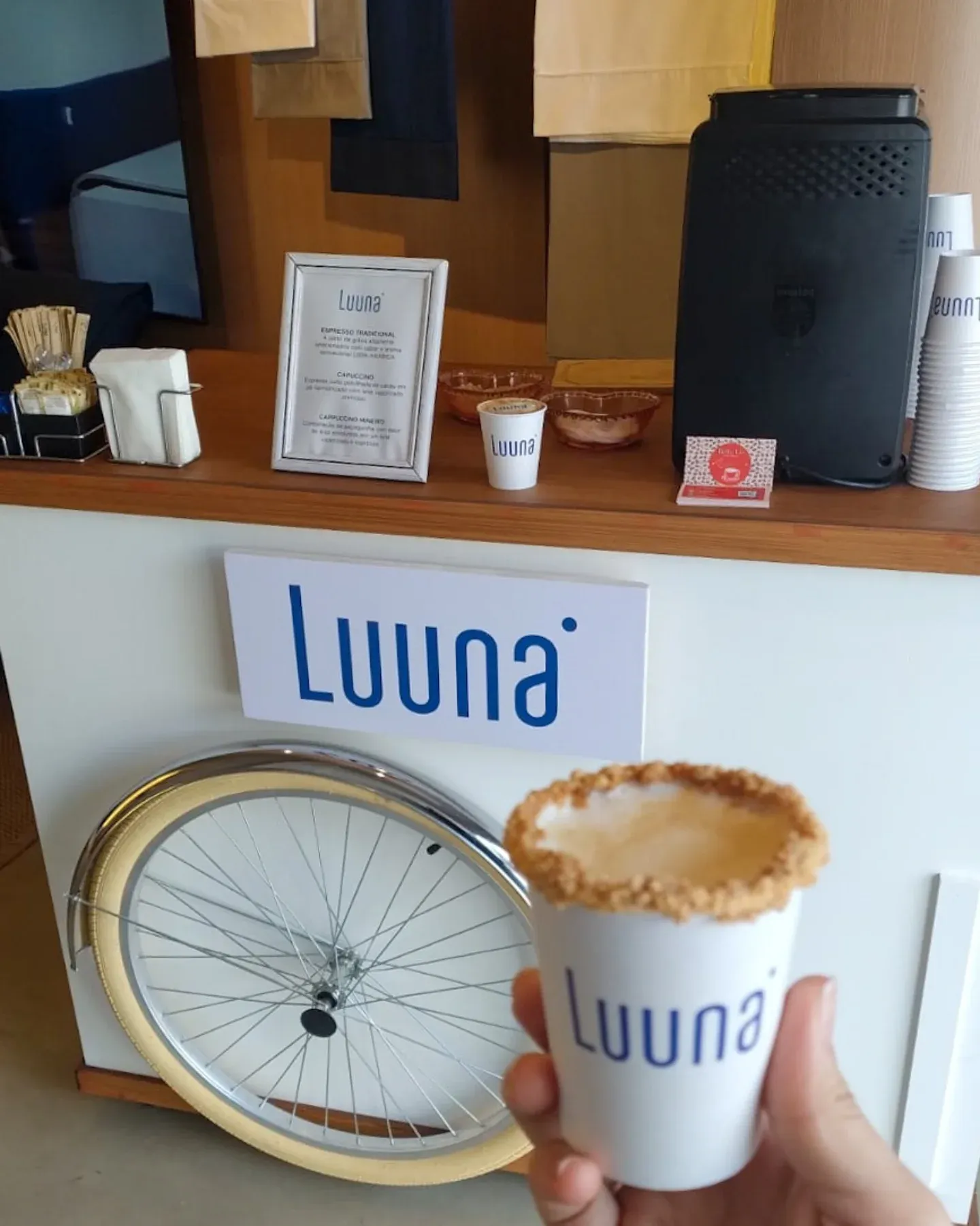 Copo personalizado Luuna com café especial em frente ao carrinho com a identidade visual da marca